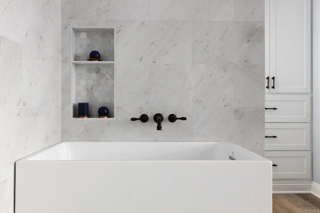 bathroom with hardwood / wood-style flooring and a bathtub