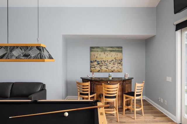 dining area with indoor bar and light hardwood / wood-style floors