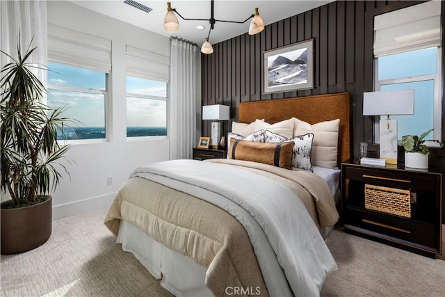 bedroom with a water view and carpet flooring