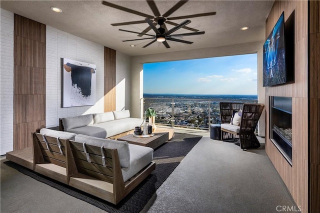 living room featuring a fireplace, a textured ceiling, and ceiling fan