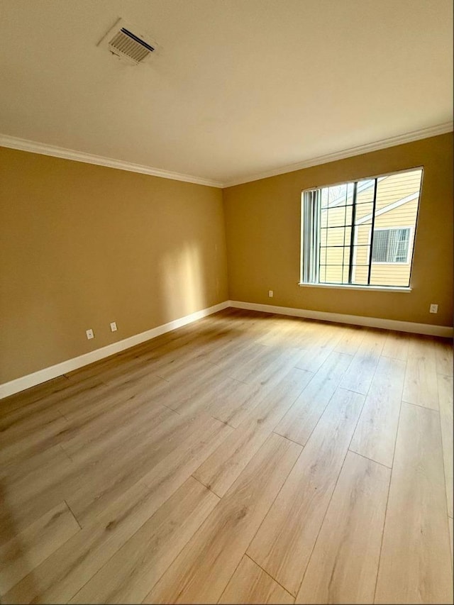 unfurnished room featuring crown molding and light wood-type flooring