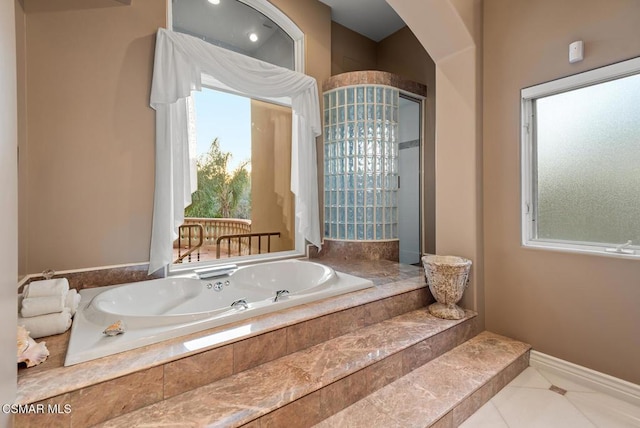 bathroom featuring tiled tub and tile patterned floors