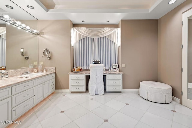 bathroom with tile patterned flooring, a tray ceiling, and vanity