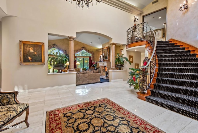 tiled foyer entrance featuring decorative columns and a towering ceiling