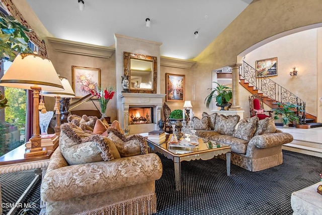 living room featuring lofted ceiling and ornate columns