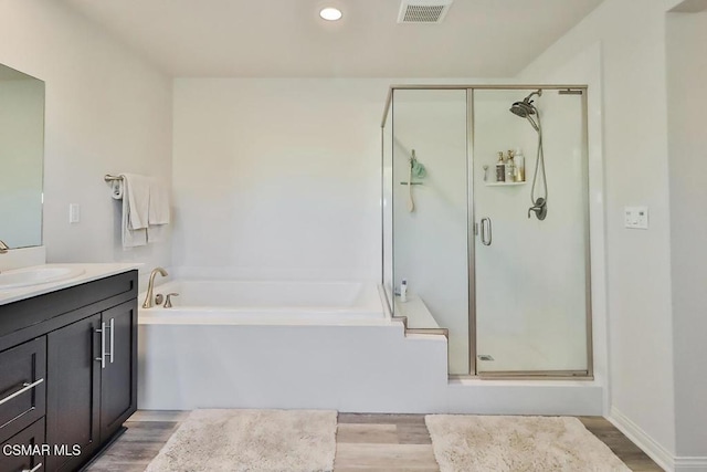 bathroom with vanity, hardwood / wood-style flooring, and separate shower and tub