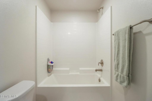 bathroom with toilet and bathing tub / shower combination