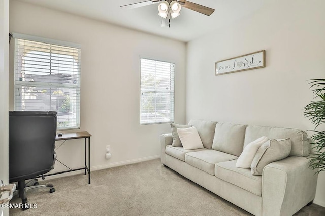 carpeted home office featuring ceiling fan