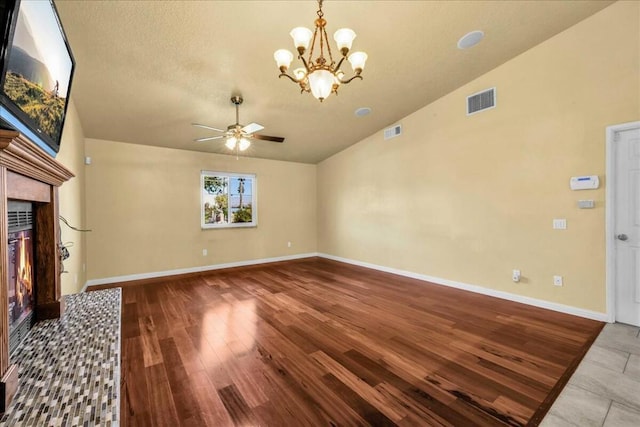 unfurnished living room with a premium fireplace, hardwood / wood-style flooring, ceiling fan with notable chandelier, and lofted ceiling