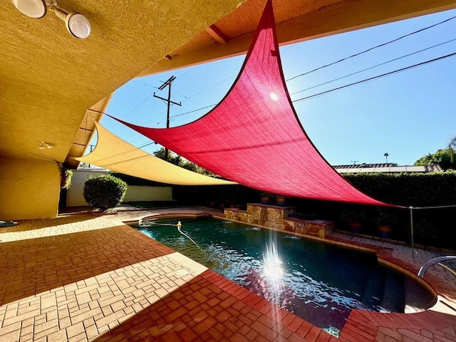 view of swimming pool with pool water feature and a patio