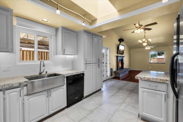 kitchen with sink, black dishwasher, gray cabinets, and stainless steel refrigerator