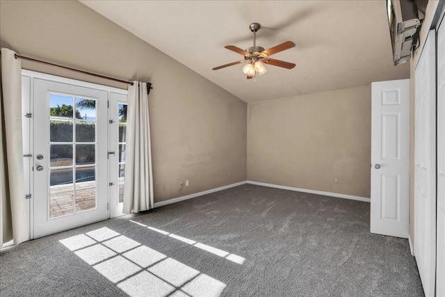 empty room featuring ceiling fan, dark carpet, and vaulted ceiling