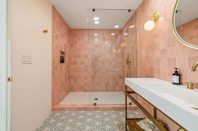 bathroom featuring tiled shower, tile walls, tile patterned floors, and sink