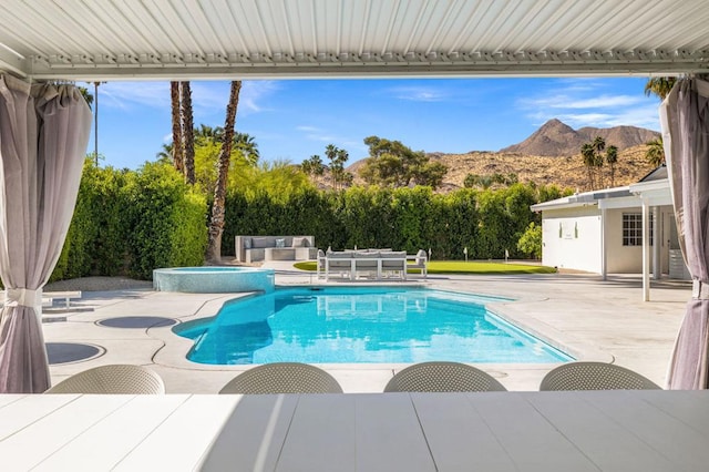 view of swimming pool with a mountain view and a patio