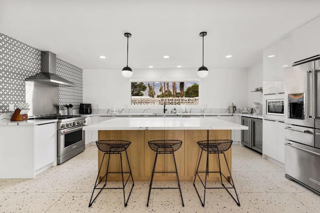 kitchen with a kitchen island, white cabinets, high end appliances, and decorative light fixtures