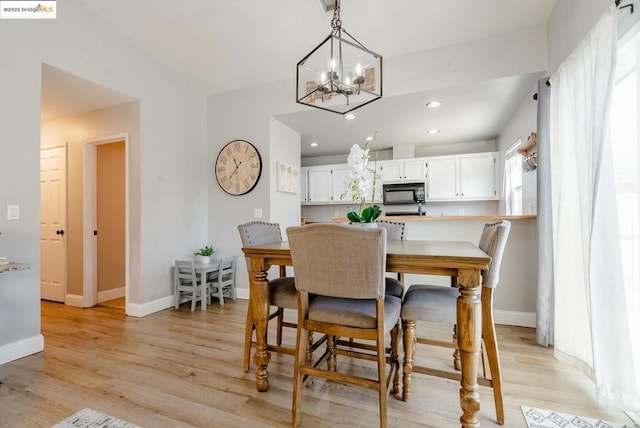 dining area with an inviting chandelier and light hardwood / wood-style floors