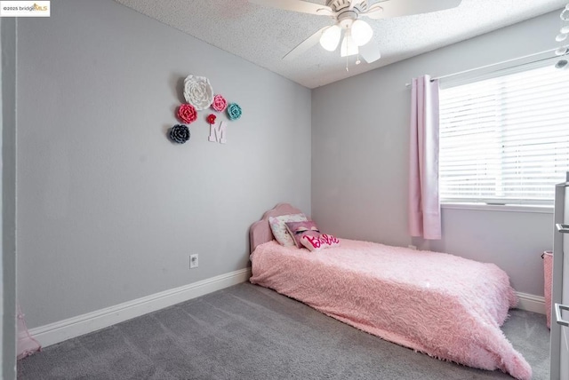 carpeted bedroom featuring ceiling fan and a textured ceiling