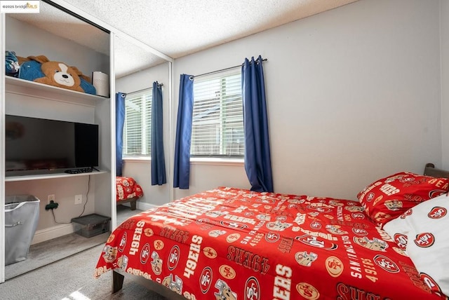 bedroom with a textured ceiling and carpet floors