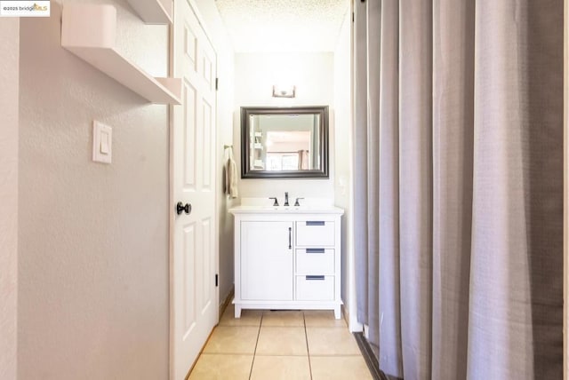 hall featuring a textured ceiling and light tile patterned floors