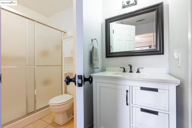 bathroom featuring vanity, a shower with shower door, tile patterned floors, and toilet