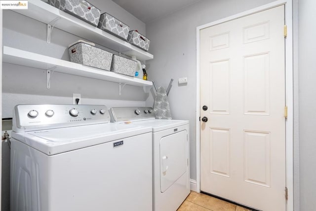 laundry room with light tile patterned floors and washing machine and clothes dryer