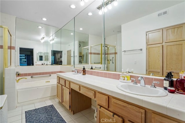 bathroom with tile patterned floors, shower with separate bathtub, and vanity