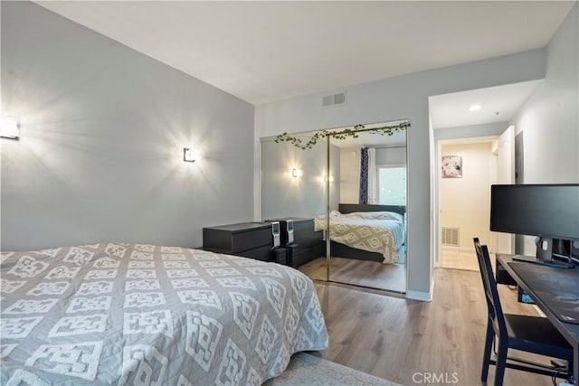 bedroom with light hardwood / wood-style floors and a closet