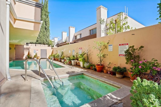 view of swimming pool featuring a patio area and a community hot tub