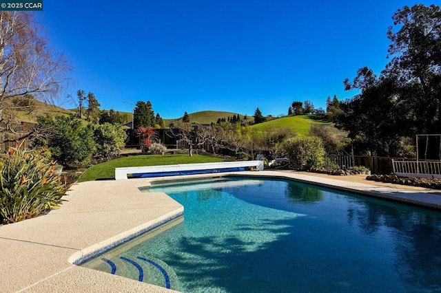 view of pool with a mountain view and a lawn