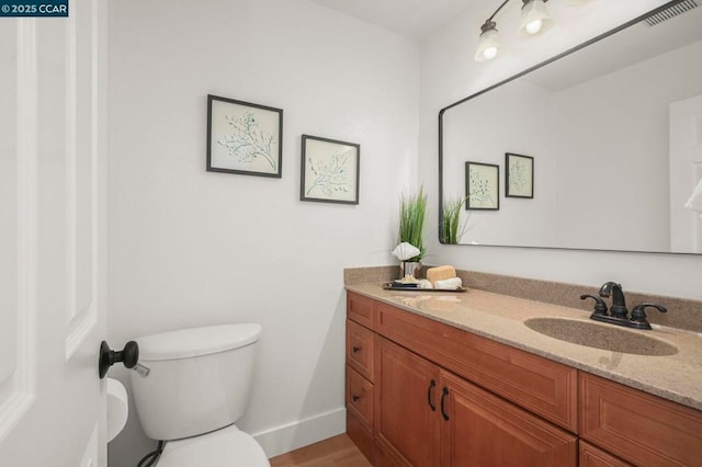 bathroom featuring vanity, hardwood / wood-style flooring, and toilet