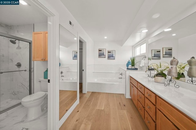 full bathroom featuring hardwood / wood-style flooring, vanity, separate shower and tub, and toilet