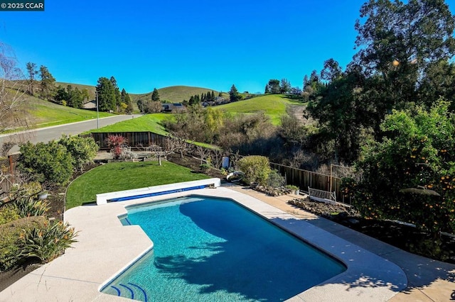 view of swimming pool with a mountain view and a yard