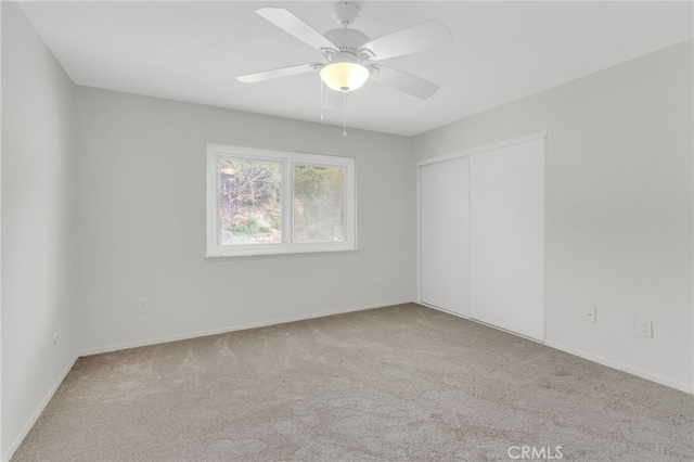 carpeted spare room featuring ceiling fan