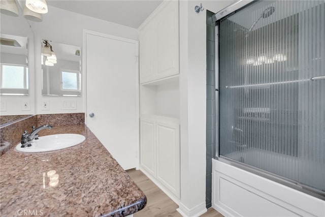 bathroom featuring vanity, bath / shower combo with glass door, and hardwood / wood-style floors