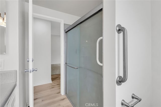 bathroom featuring vanity, hardwood / wood-style flooring, and walk in shower