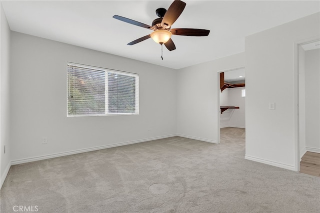 unfurnished room with light colored carpet and ceiling fan