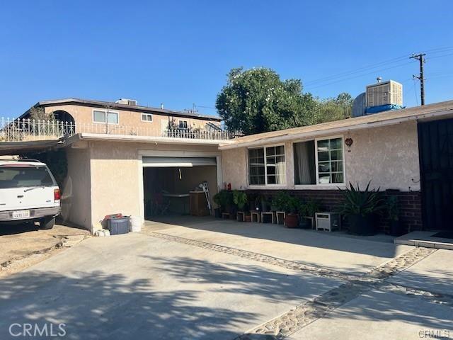 view of front of property featuring central AC and a garage