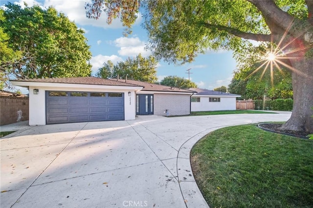 ranch-style house featuring a front yard and a garage