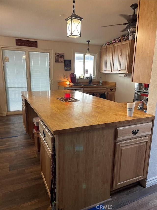 kitchen with ceiling fan, wood counters, decorative light fixtures, and dark hardwood / wood-style flooring