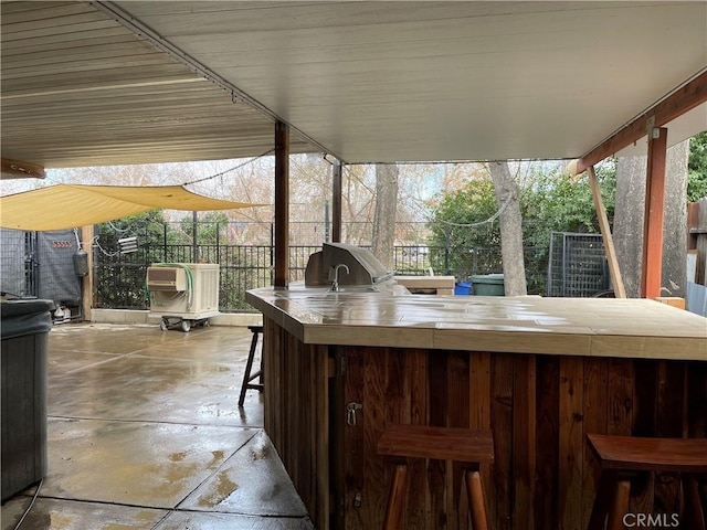 view of patio / terrace with area for grilling, an outdoor bar, and an outdoor kitchen