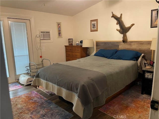 bedroom with lofted ceiling, dark wood-type flooring, and a wall mounted AC