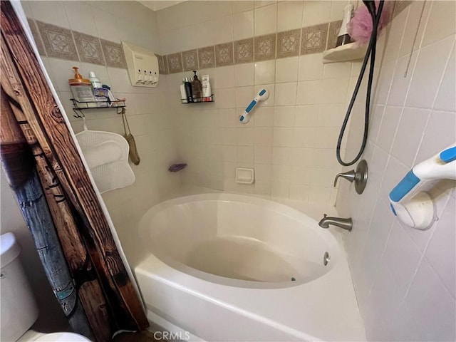 bathroom featuring shower / tub combo, tile walls, and toilet