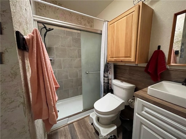 bathroom with hardwood / wood-style flooring, vanity, an enclosed shower, and toilet