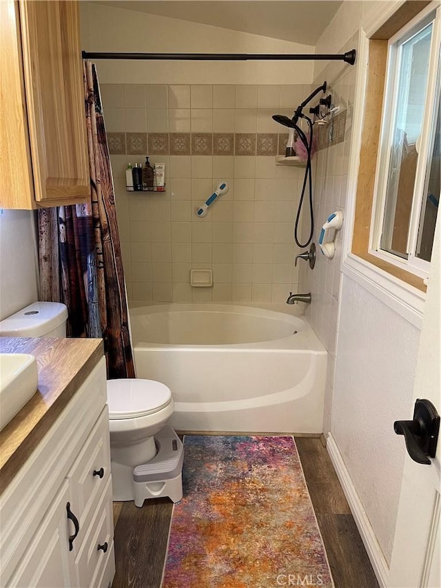 full bathroom featuring vanity, hardwood / wood-style flooring, shower / bath combination with curtain, and toilet