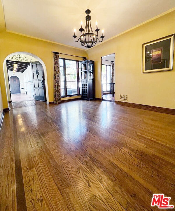 interior space with dark wood-type flooring and an inviting chandelier