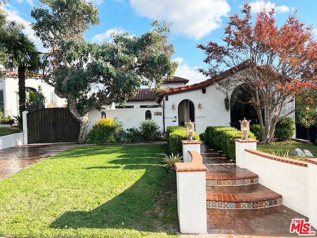 mediterranean / spanish home featuring a front lawn