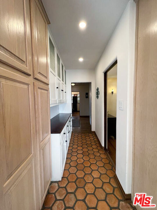 kitchen with light brown cabinetry and dark tile patterned floors