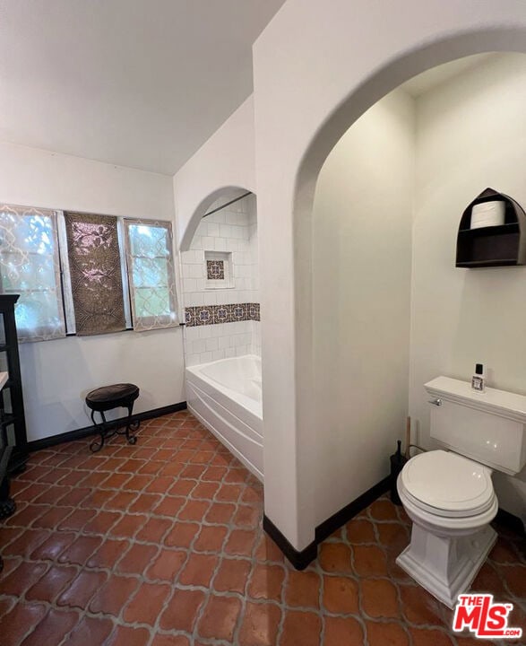 bathroom featuring a washtub and toilet