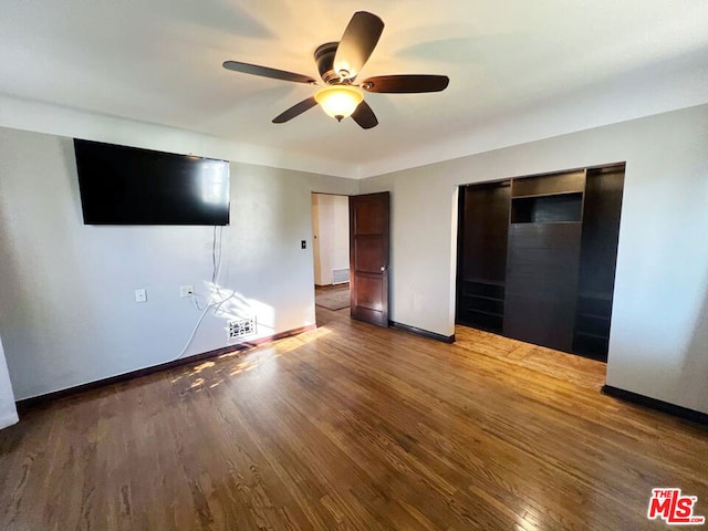 unfurnished bedroom with hardwood / wood-style flooring, a closet, and ceiling fan