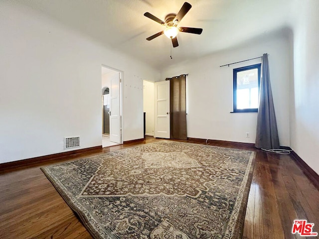 empty room featuring ceiling fan and dark wood-type flooring